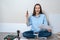 Portrait ofyoung smiling woman sitting onfloor with screwdriver and furniture Assembly instructions,copy space