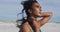 Portrait oh relaxed hispanic woman standing in sun and wind on beach