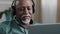Portrait old bald African businessman with gray beard aged male in headset teacher in headphones lead online webinar