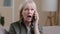 Portrait old caucasian woman angry senior lady furious frustrated annoyed mature female talking mobile phone calling