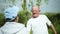 Portrait of an old cheerful man performing physical exercises taking care of his health together with his wife