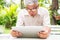 Portrait of an old elderly Asian man is holding a computer laptop and surprised after got some email and read some news in the