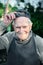 Portrait of an old farmer in a baseball cap. The 87 - year-old smiles and adjusts his baseball cap after work. Active ageing. To