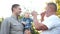 Portrait of old gray haired father, his handsome son and lovely grandson looking straight and smiling amid the sunset in