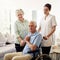 Portrait of old man in wheelchair with wife and caregiver at nursing home for disability and rehabilitation. Healthcare