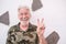 Portrait of old senior optimistic man smiling doing positive sign with hand. White haired face expression, white background