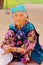 Portrait of an old Uzbek woman traditionally and colorfully dressed in Uhum village