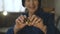 Portrait of old woman holds two golden bitcoins in hands at camera