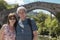 portrait of an older couple in front of the roman bridge of Cangas de Onis in Asturias, Spain