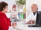 Portrait: older doctor with experience talking with senior woman