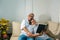 Portrait of an older Hispanic couple with glasses reading their favorite books while on the couch