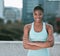 Portrait of one confident young african american woman standing with arms crossed ready for exercise outdoors