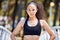 Portrait of one confident young mixed race woman standing with hands on hips ready for exercise outdoors. Determined