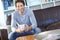 Portrait one handsome man sitting alone on the sofa in his living room, smiling and drinking coffee. Mature man feeling