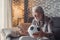 Portrait of one happy old man celebrating victory of his love team of football or soccer on the sofa. Senior watching match on his