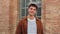 Portrait of one student teenage male smiling and looking at camera at university campus. Guy standing and staring front