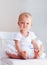 Portrait of one year old baby girl with serious face expression and fiery temper posing on the chair