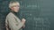 Portrait of online school tutor writing on chalkboard and talking teaching remote class