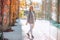 Portrait oof good-looking middle-aged woman in checkered jacket, roll-neck sweater and white jeans pose on paving flag.