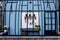 A portrait of an open outdoor gardening shed. The shed is made of a wooden wall and bars like a bird cage. In the shed their are