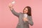 Portrait of optimistic businesswoman in suit jacket making video call with thumbs up gesture, having online conference