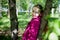 Portrait of a ordinary cute girl in the green park with blossoming apple tree with white flower in a springtime