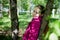 Portrait of a ordinary cute girl in the green park with blossoming apple tree with white flower in a springtime