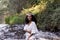 Portrait outdoors of a beautiful young afro american woman at sunset. Green background. Lifestyle at nature. Wearing white casual