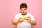 Portrait of an overweight young overweight man playing mobile games on a sad-faced smartphone. Fat gamer guy plays online games on