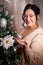 Portrait of Owerweight elegant Woman at Christmas room. Fat plumb pretty girl in a beautiful dress for a holiday