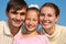 Portrait of parents and daughter against sky