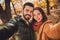 Portrait of passionate bonding couple girl guy make selfie in fall september park wear october coats