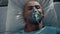 Portrait patient breathing oxygen mask lying in bed hospital emergency unit.