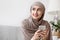 Portrait of pensive arabic girl in hijab with smartphone in hands