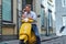 Portrait of a pensive stylish guy dressed in a in a white shirt and jeans sitting on yellow classic italian scooter on