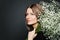 Portrait of perfect mature woman with flowers close up on black background