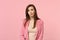 Portrait of perplexed puzzled young woman wearing jacket standing and looking camera isolated on pastel pink wall