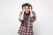 Portrait of perplexed tired young man in casual clothes looking camera putting hands on head isolated on white wall