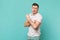 Portrait of perplexed young man in casual clothes standing showing biceps, muscles isolated on blue turquoise wall