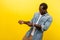 Portrait of persistent young man pretending to hold rope in hands and pull. indoor studio shot isolated on yellow background