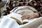 A portrait of a person fallen asleep under a blanket while reading a book. The hand of the person is still on the book at the spot