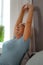 Portrait photo of lady stretching on the bed with sheets.