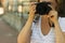 Portrait of a photographer covering her face with the camera.. Photographer woman girl is holding dslr camera taking photographs