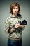 portrait of a photographer holding superb retro camera in her tender hands. Brunette looks upwards with a sly glance and serious p