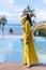 Portrait photography Yellow dress traveler Asian girl wearing hat and sunglass acting post beside the beach on sunshine at Island