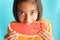 Portrait picture asian little girl eating watermelon on blue background. A girl kid so happy after eat watermelon