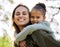 Portrait, piggyback and a mother and child in a park for playing, bonding and quality time. Smile, hug and a young mom