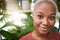 Portrait, plant and flare with a black woman gardener in her home for sustainability or green growth. Face, beauty and