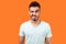 Portrait of playful handsome brunette man winking and flirting at camera with grin. indoor studio shot isolated on orange