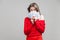 Portrait of playful rich beautiful woman in red dress holding money, isolated on gray background